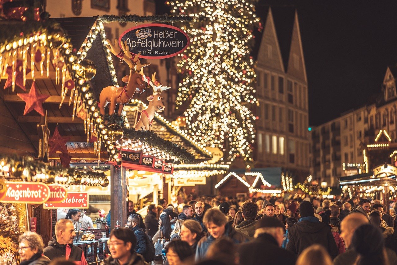 christmas market with people wandering the streets and christmas lights